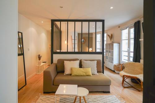 un salon avec un canapé et un miroir dans l'établissement Appartement chill au cœur du Marais, à Paris