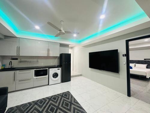 a living room with a kitchen with a tv on the ceiling at Patong best location Apartments, 2 bedrooms in Patong Beach