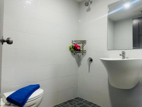 a white bathroom with a toilet and a sink at Patong best location Apartments, 2 bedrooms in Patong Beach