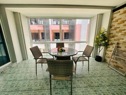 a dining room with a table and chairs and a window at Patong best location Apartments, 2 bedrooms in Patong Beach