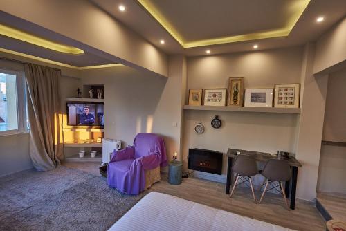 a living room with a purple chair and a tv at Lycabettus View Kaniggos in Athens