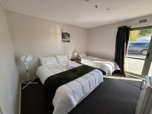 a bedroom with two beds and a window at Leopard Hotel in  Waipukurau