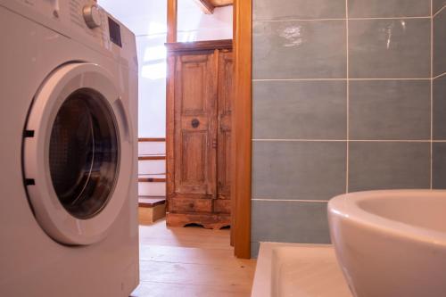 een badkamer met een wasmachine en een wastafel bij La Cambusa Apartment in Alghero