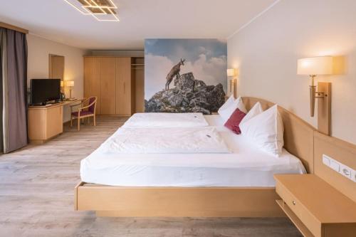 a bedroom with a bed with a painting of a giraffe at Hotel Acherl in Achenkirch