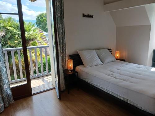 une chambre avec un lit et un balcon avec vue dans l'établissement Maison familiale avec piscine, à Nay