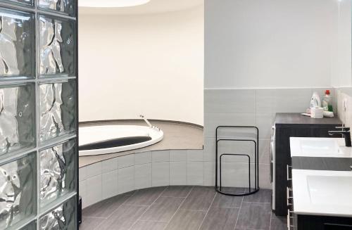 a bathroom with two stools and a sink and a tub at RIOs Apartments in Scharnitz