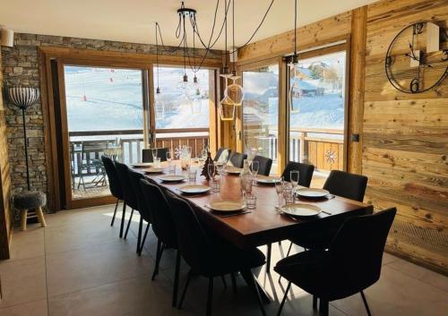 une salle à manger avec une longue table et des chaises dans l'établissement La Loge Des Chats, à La Toussuire