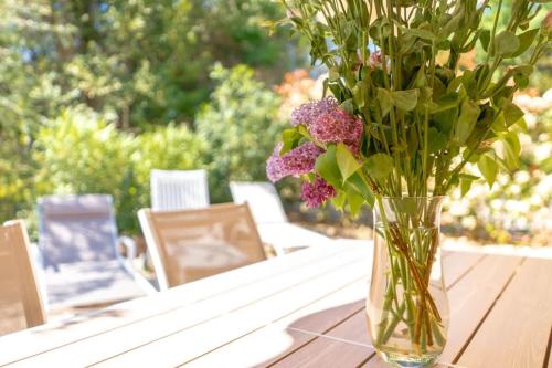 un vase rempli de fleurs violettes assises sur une table dans l'établissement Le Cottage l Pool & Beachside l Shellter Rentals, à Saint-Tropez