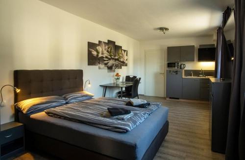 a bedroom with a bed and a kitchen with a table at RIOs Apartments in Scharnitz