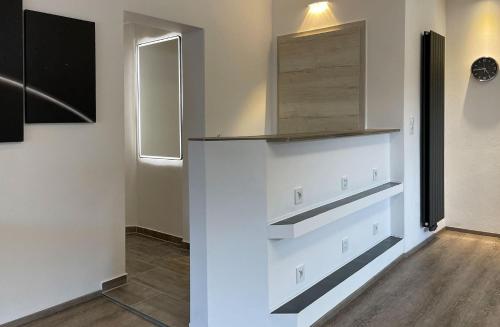 a kitchen with white cabinets and a mirror at RIOs Apartments in Scharnitz
