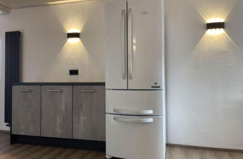 a stainless steel refrigerator in a kitchen with two lights at RIOs Apartments in Scharnitz