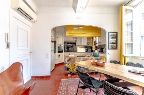 une cuisine avec une table et des chaises en bois dans l'établissement Le Seillon l Perfect Location l Shellter Rentals, à Saint-Tropez