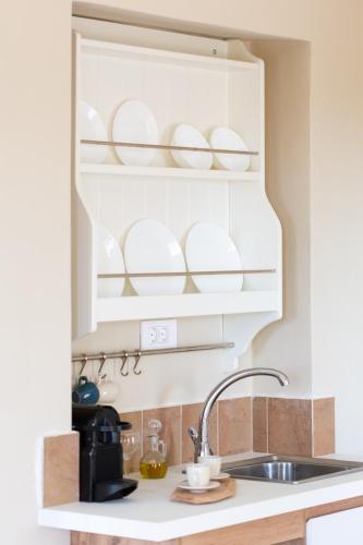 a kitchen with a sink and plates on a shelf at Villa Plaka 16 "The Bordeaux"-Drepano Nafplio in Drepana