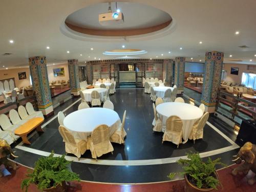 a restaurant with tables and chairs in a room at Hotel Phuntsho pelri in Thimphu