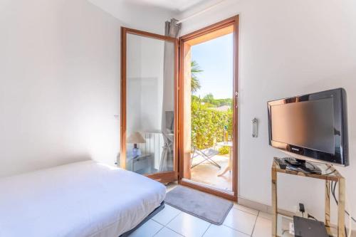 une chambre avec un lit, une télévision et une fenêtre dans l'établissement House Nartelles l BBQ & Pool l Shellter Rentals, à Sainte-Maxime