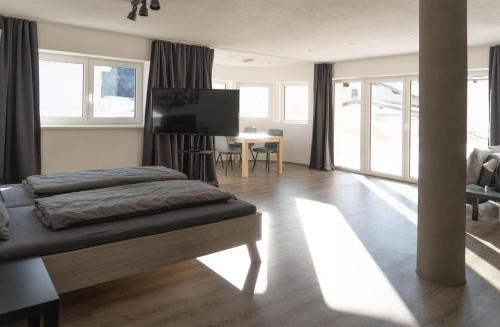 a bedroom with a bed and a dining room with a table at RIOs Apartments in Scharnitz