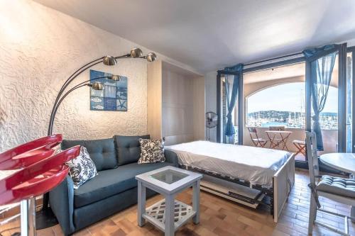 una sala de estar con un sofá y una cama en La Marina l Views & Parking l Shellter Rentals, en Cogolin