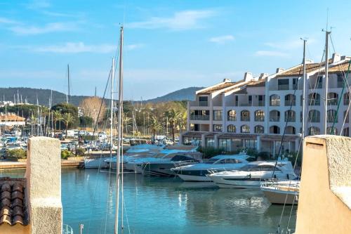 un groupe de bateaux amarrés dans un port de plaisance à côté d'un bâtiment dans l'établissement La Marina l Views & Parking l Shellter Rentals, à Cogolin