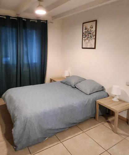a bedroom with a large bed and a table at Maisonnette Provençale in Le Thor