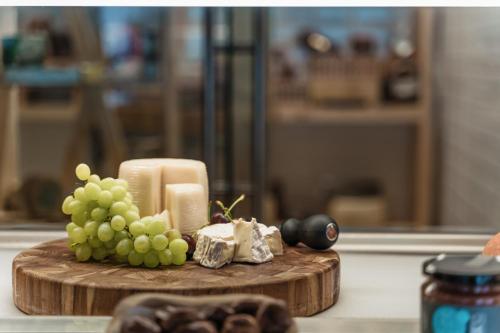 a wooden cutting board with grapes and a candle at Gennadi Grand Resort in Gennadi
