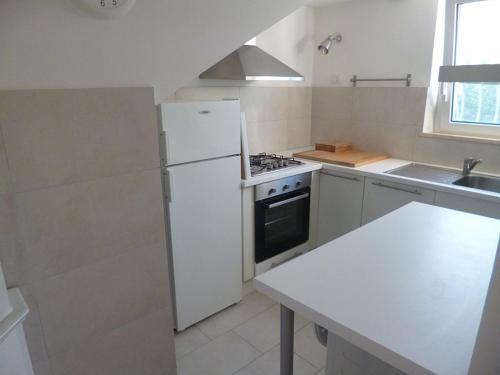 a kitchen with a white refrigerator and a stove at Trilo Simonetta a Marcelli, con aria condizionata e posto auto in Marcelli