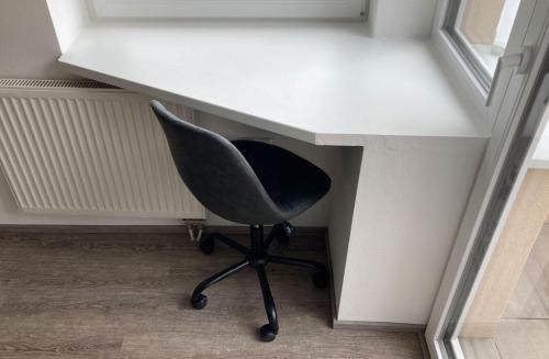 a white desk with a chair under a window at RIOs Apartments in Scharnitz