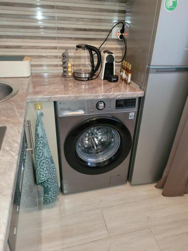 a washing machine in a kitchen with a counter at City Center Moku Apartman in Zenica