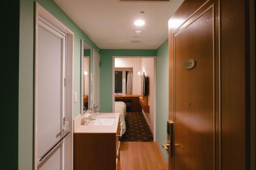 a bathroom with a sink and a mirror at Boston Plaza Kusatsu Biwa Lake - Vacation STAY 15430v in Kusatsu