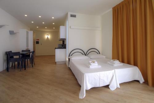 a bedroom with a white bed and a table and chairs at La Cordata Accommodation - Martinelli 55 - Mono 7 in Rho