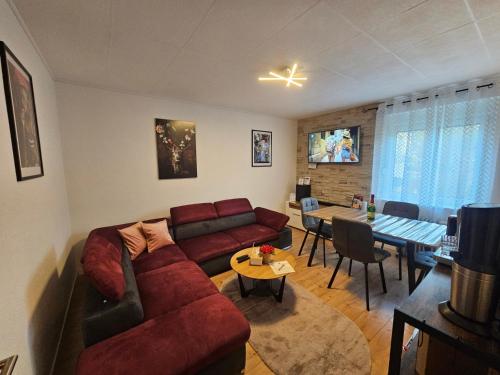 a living room with a red couch and a table at Miuti Residence in Triberg