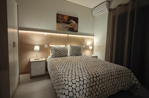 a bedroom with a bed and two lamps and a painting at Casa em Aldeia Pescadores in Vila Nova de Gaia