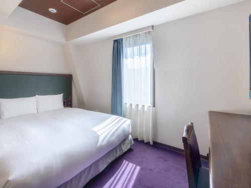a hotel room with a bed and a window at Hotel Wing International Select Ikebukuro in Tokyo