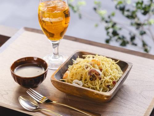 a tray with a bowl of pasta and a glass of beer at Hotel Wing International Select Ikebukuro in Tokyo