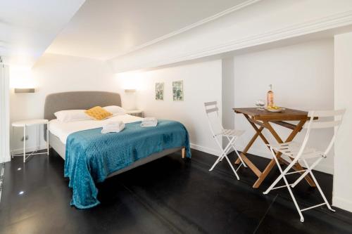 une chambre avec un lit, une table et des chaises dans l'établissement Maison Bianchi - Duplex old town, à Nice