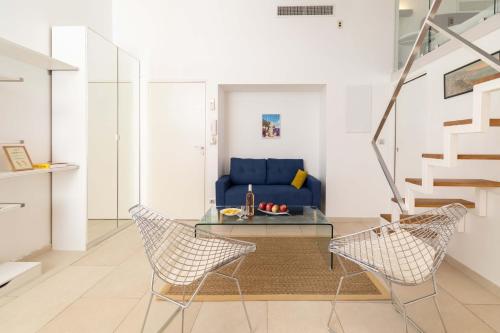 un salon avec un canapé bleu et des chaises dans l'établissement Maison Bianchi - Duplex old town, à Nice