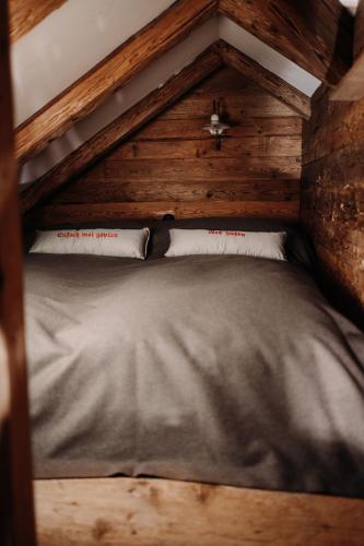 a bed in a wooden room with two pillows at Forsthaus Wartenfels in Thalgau