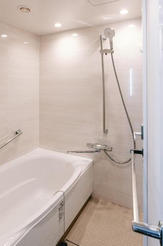 a white bath tub in a bathroom with a shower at Boston Plaza Kusatsu Biwa Lake - Vacation STAY 15431v in Kusatsu