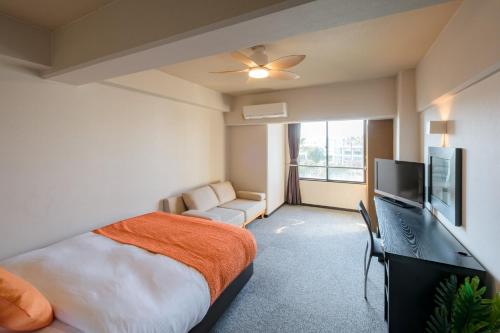 a bedroom with a bed and a flat screen tv at Miyazaki Mango Hotel - Vacation STAY 58252v in Miyazaki