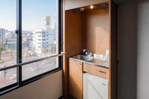 a bathroom with a sink and a window at Miyazaki Mango Hotel - Vacation STAY 58252v in Miyazaki