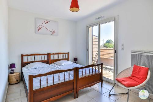 Biscarrosse bourg Duplex proche commerces 6 couchages في بيسكاروس: غرفة نوم بها سرير وكرسي ونافذة