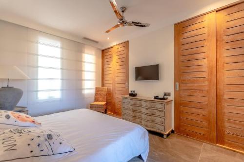 une chambre avec un lit et une commode avec une télévision dans l'établissement Loft Jasmin l Terrace & Space l Shellter Rentals, à Saint-Tropez