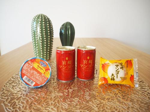 two red cans sitting on a table next to a cactus at Miyazaki Mango Hotel - Vacation STAY 58309v in Miyazaki