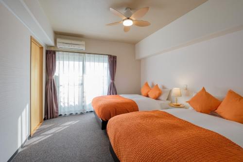 una camera d'albergo con due letti e una finestra di Miyazaki Mango Hotel - Vacation STAY 58315v a Miyazaki