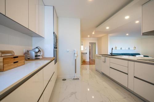 a kitchen with white cabinets and a counter top at Brisa do Oceano in Ovar