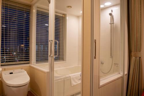 a bathroom with a shower and a toilet and a tub at Boston Plaza Kusatsu Biwa Lake - Vacation STAY 15436v in Kusatsu