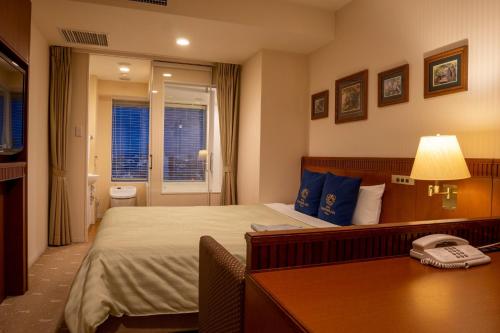 a hotel room with a bed and a telephone at Boston Plaza Kusatsu Biwa Lake - Vacation STAY 15436v in Kusatsu
