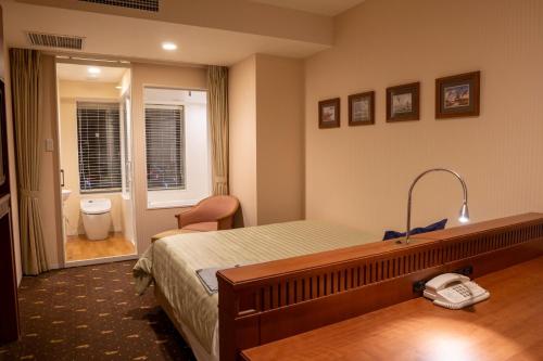 une chambre d'hôtel avec un lit et une salle de bain dans l'établissement Boston Plaza Kusatsu Biwa Lake - Vacation STAY 15434v, à Kusatsu