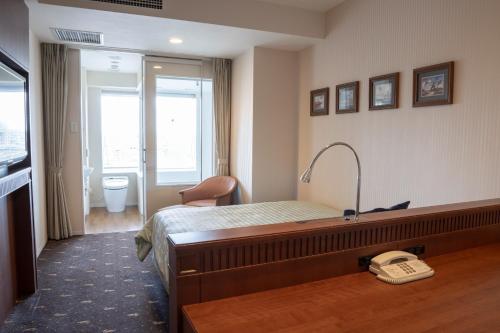 une chambre d'hôtel avec un lit et un téléphone par terre dans l'établissement Boston Plaza Kusatsu Biwa Lake - Vacation STAY 15434v, à Kusatsu