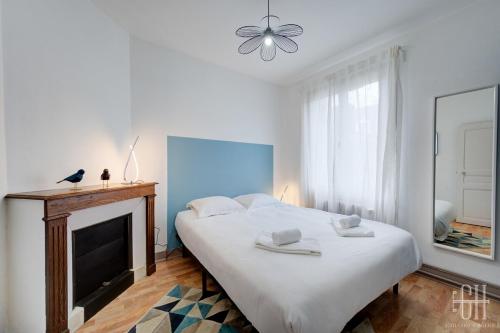 a bedroom with a large bed and a fireplace at Maison familiale bords de Loire avec jardin et 3 Chambres in Saint-Cyr-sur-Loire