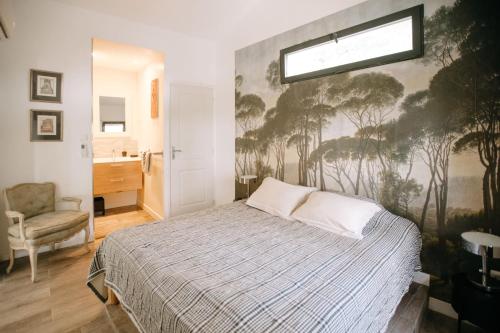 une chambre avec un lit avec un tableau sur le mur dans l'établissement The Aviary - Pernes-les-Fontaines, à Pernes-les-Fontaines